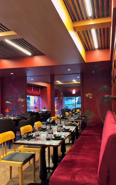 hăo dining room with red velvet booths, floral murals, and elegant table settings